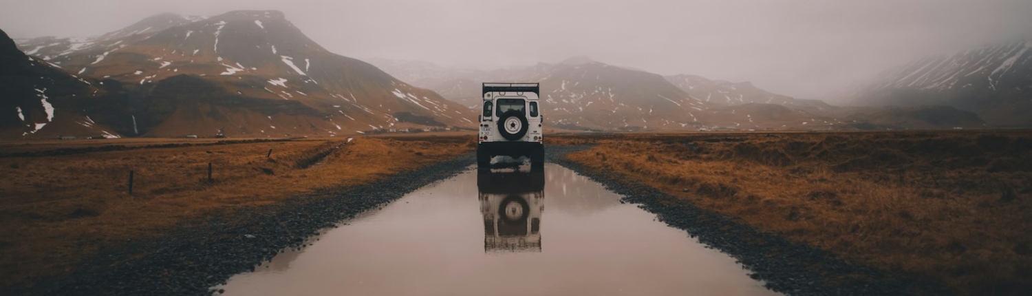 white and black vehicle on road with water during daytime