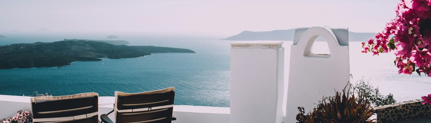 two brown wooden chairs beside the wall