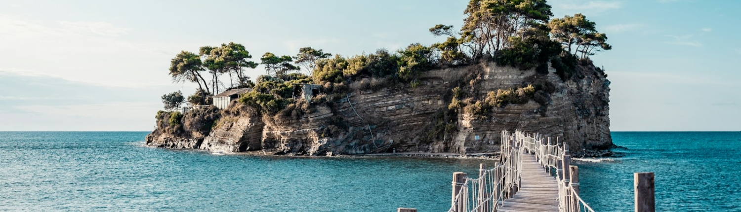 brown wooden bridge over blue sea under blue sky during daytime