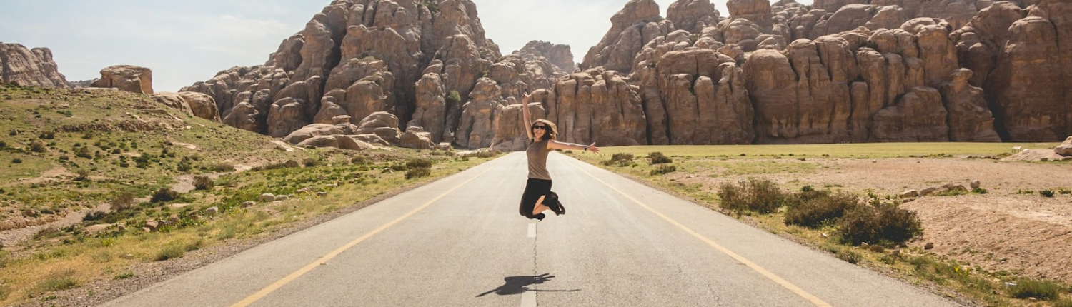 woman jumping on the middle of road