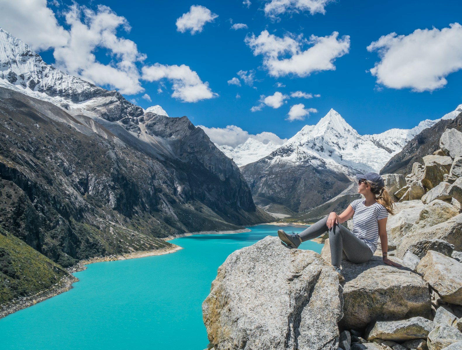 girl sitting on rock near body of water at daytime