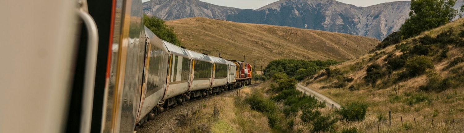 white train with the distance of mountain during daytime